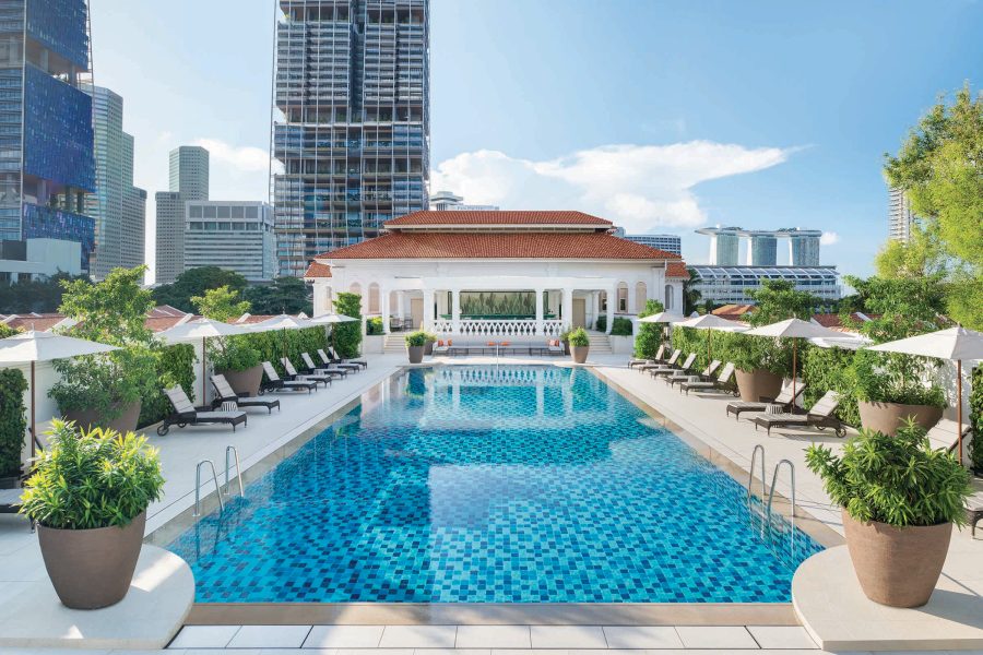 The outdoor pool at Raffles Hotel Singapore has views of Marina Bay Sands in the distance.